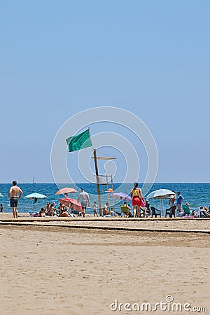 Green flag installed on top of lifeguard seat on Patacona beach in Valencia Editorial Stock Photo