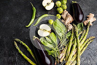 Green fresh seasonal vegetables on black table top background Stock Photo