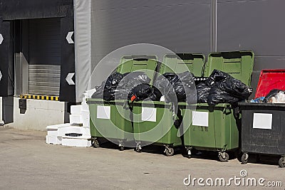Green garbage containers near large food shop Stock Photo