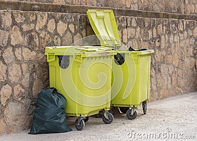 Green garbage containers near the wall Stock Photo