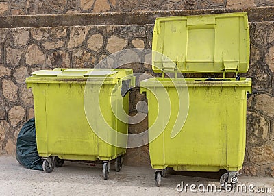 Green garbage containers near the wall Stock Photo