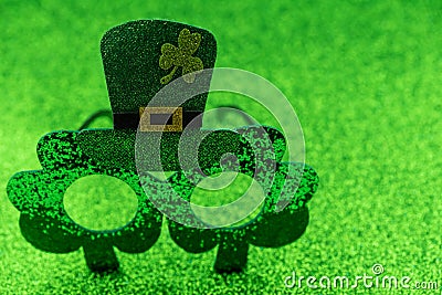 Green glasses with shamrock for Saint St Patrickâ€™s day holiday celebration on green background. Funny sparkle eyeglasses, happy Stock Photo