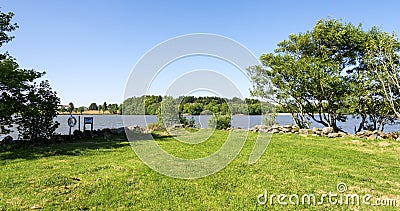 A green grass lawn on a shore of Halandsvatnet lake Editorial Stock Photo
