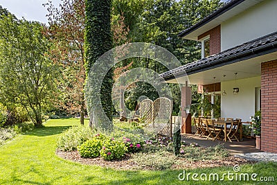 Green grass and trees next to garden furniture Stock Photo