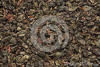 Green gunpowder tea texture. Green tea leaves background. Green tea with safflower flower petals Stock Photo