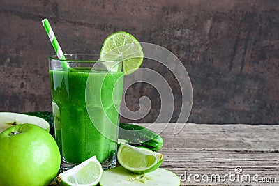 Green healthy smoothie in a glass with spinach, apple, cucumber and lime with a straw. detox drink Stock Photo