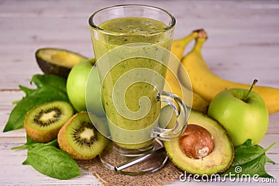 Green healthy smoothie in a tall glass. Detox drink. Close-up. Stock Photo
