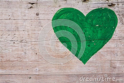 Green heart on a wooden background Stock Photo