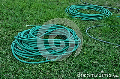 Green hoses for lawn irrigation, folded into several coils Stock Photo