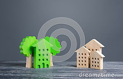 Green house with trees and ordinary residential buildings. Energy efficiency, profitability in maintenance. Zero carbon emissions Stock Photo