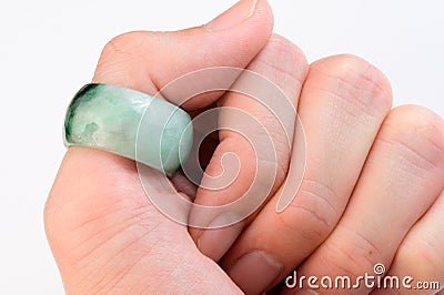 Green jade ring on thumb finger Stock Photo