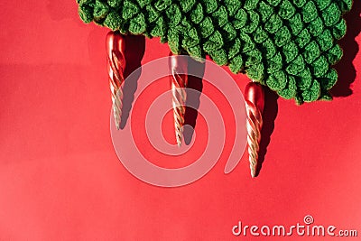 Green knitted handmade Christmas tree with Christmas toys in the form of orange icicles. Beautiful red gradient Christmas Stock Photo