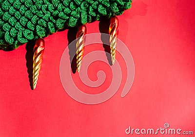 Green knitted handmade Christmas tree with Christmas toys in the form of orange icicles. Beautiful red gradient Christmas Stock Photo