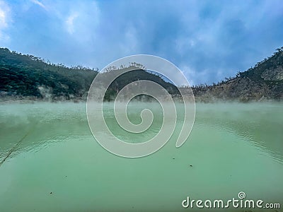 Green lake mirrored with fog above and green cliffs as a background Stock Photo