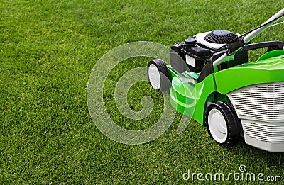 Green lawnmower on green lawn Stock Photo