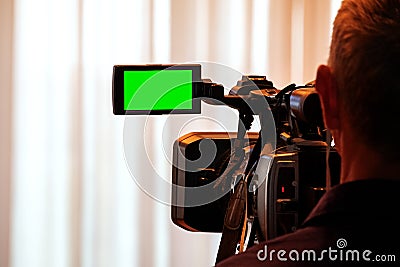 Green LCD display on high definition television camera. Videographer at work removes the story for the news. Template template for Stock Photo