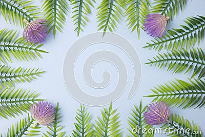 Green leaves with flowers on a light blue background with copy space. Flat lay scene Stock Photo