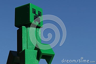 Green Lego Minecraft Creeper figure in morning sunshine. Editorial Stock Photo