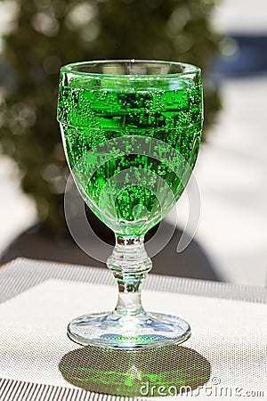 Green lemonade Tarragon in a glass glass on a blurry background, close-up. Green drink from healthy herbs Tarragon Stock Photo