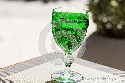 Green lemonade Tarragon in a glass glass on a blurry background, close-up. Green drink from healthy herbs Tarragon Stock Photo