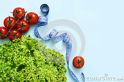 Green lettuce, tomatoes and centimetr on a blue background Stock Photo