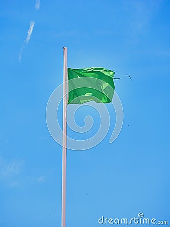 A green lifeguard flag on a beach Stock Photo