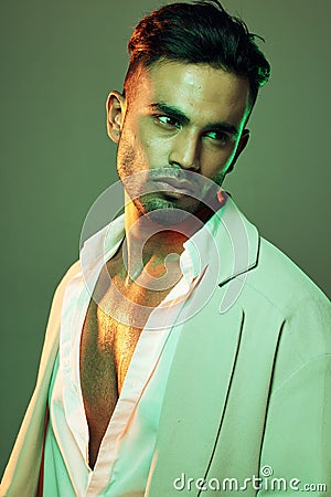 Green light, fashion and man in studio isolated on a green background. Beauty, neon light and male model from Brazil Stock Photo