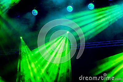 Green light rays from the spotlight through the smoke at the theater or concert hall. Lighting equipment for a performance Stock Photo