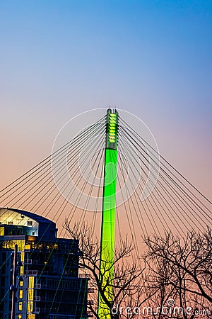 Green lighting of tower and cables of Bob Kerrey foot bridge with backdrop of River Front Condominiums Omaha Nebraska Stock Photo