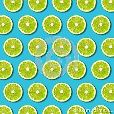 Green lime slices pattern on vibrant turquoise background Stock Photo