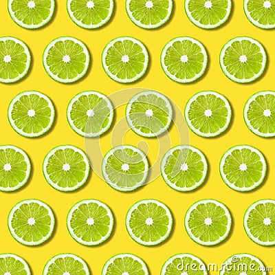 Green lime slices pattern on vibrant yellow color background Stock Photo