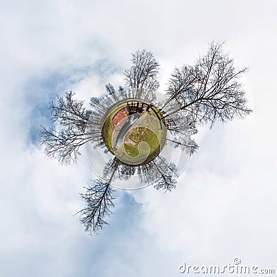 Green little tiny planet with trees near gateway lock sluice construction on river, white clouds and soft blue sky of amusement Stock Photo