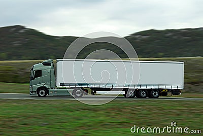 Green lorry with white trailer drive fast Stock Photo