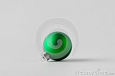 Green matte Christmas ball on a seamless grey background Stock Photo