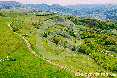 Green meadows, small houses and roads in Transylvania, Romania Stock Photo