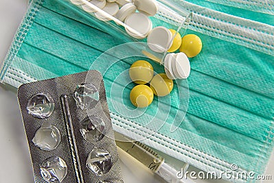 Green medicine mask, white and yellow pills, healthcare concept Stock Photo