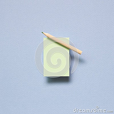 Green memo paper, sticky notes with colored pencil on blue background Stock Photo