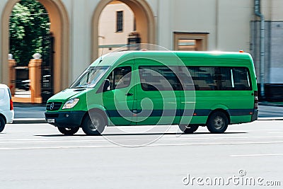 Green Mercedes-Benz Sprinter minibus van on the city road. Commercial auto in fast motion with blurred background Editorial Stock Photo
