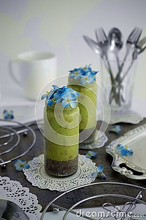 Green milkshake with blue flowers Stock Photo