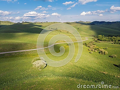 Green mountain meadows over the hills and a walking road into the mountains Stock Photo