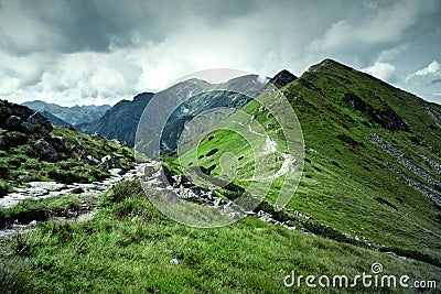 Green mountains and dark cloudy sky. Stock Photo