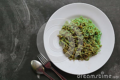 green noodles, or Spinach pasta , Zucchini raw vegan pasta dip, and tomatoes on plate. Stock Photo