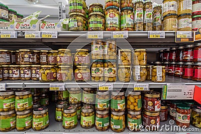 Green olives in glass jars on the shelves Editorial Stock Photo