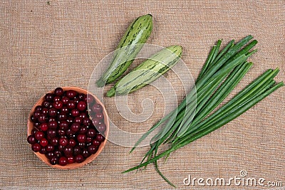 Green onions zucchini marrow and frozen cherries lie on rural table Stock Photo