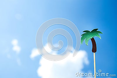 Green palm tree on stick on blue sky background Stock Photo