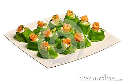 Green pancakes (crepes) filled with salmon and cream cheese on a white plate. Stock Photo
