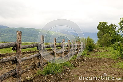 Green pasture and fence at mountains Stock Photo