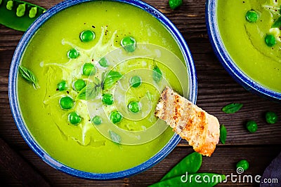 Green pea soup on wooden rustic background Stock Photo