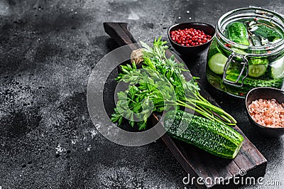 Green pickle cucumbers in a glass jar. Natural product. Black background. Top view. Copy space Stock Photo