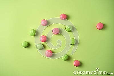 Green and pink mini macarons on light green background Stock Photo